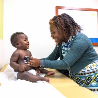 Dr. Tachele Candia Anderson checking heart of toddler in ULPS Clinic